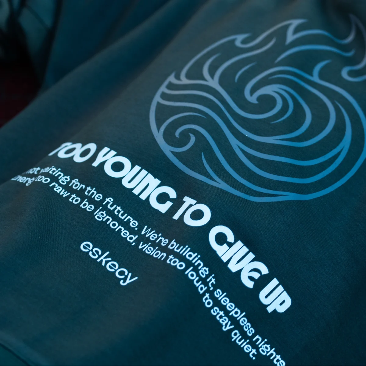Eskecy Fire and Ice Hoodie – navy hoodie with wave graphic and "Too Young To Give Up" print