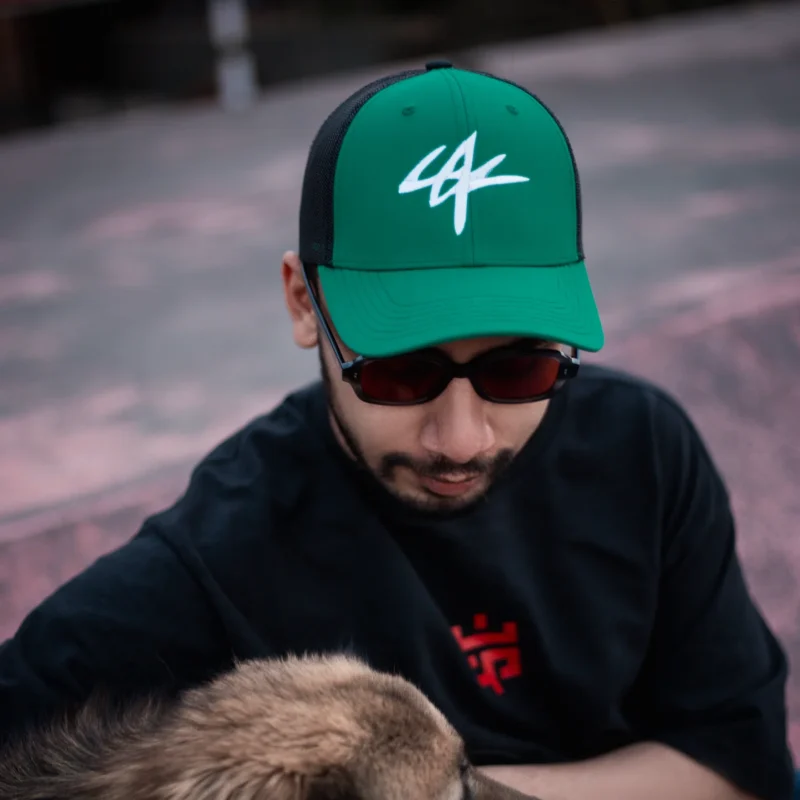Model wearing the Eskecy Rainforest Cap in green with embroidered logo
